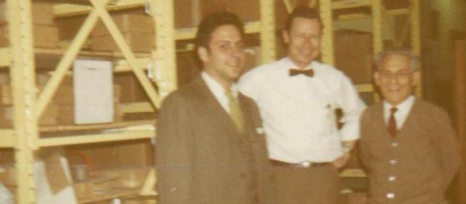 Archival photo: three men in the parts warehouse